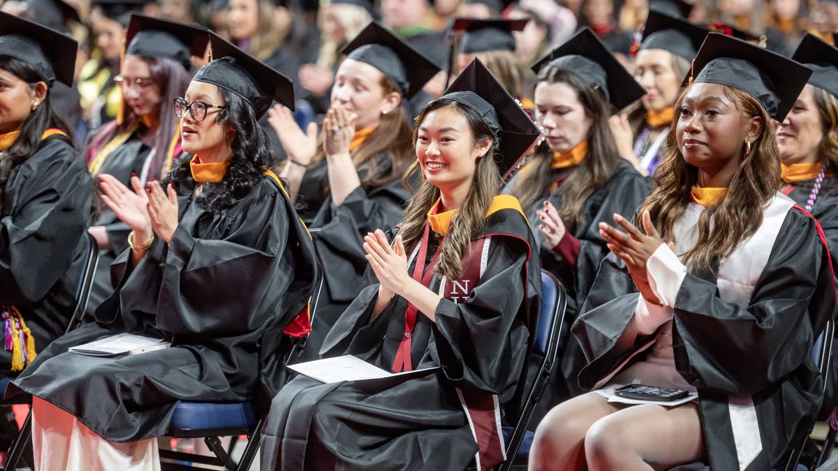 Students in cap and gowns at Commencement. 