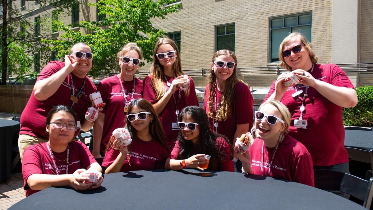 MCPHS Students wearing sunglasses and sitting at a table