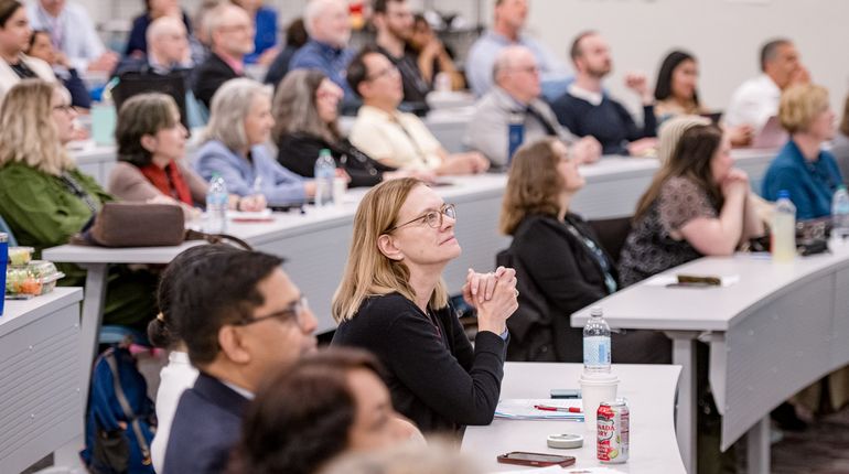 MCPHS faculty sit in a classroom where they were recognized for their achievements during the University’s annual Faculty Day.