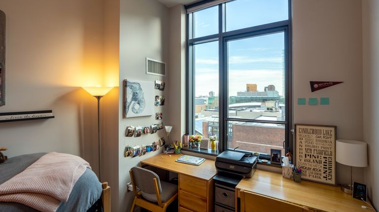 Inside of dorm window showing a bed with stuffed animals on top. .jpg