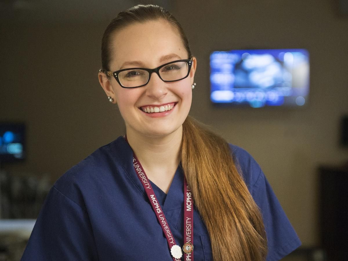 Smiling female student in scrubs. 