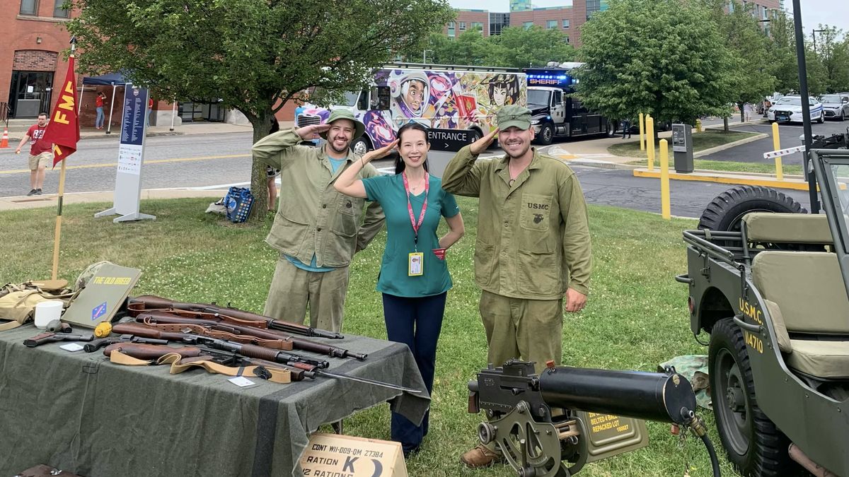 MCPHS faculty member and two veterans salute at the Veterans StandDown event.