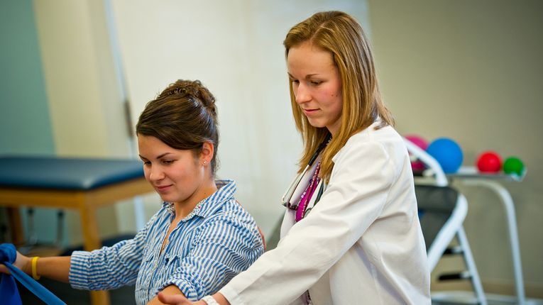 A female PT student works with a patient.