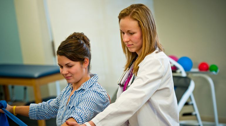 A female PT student works with a patient.