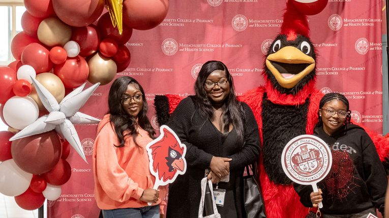 New MCPHS students stand with Red the Cardinal.