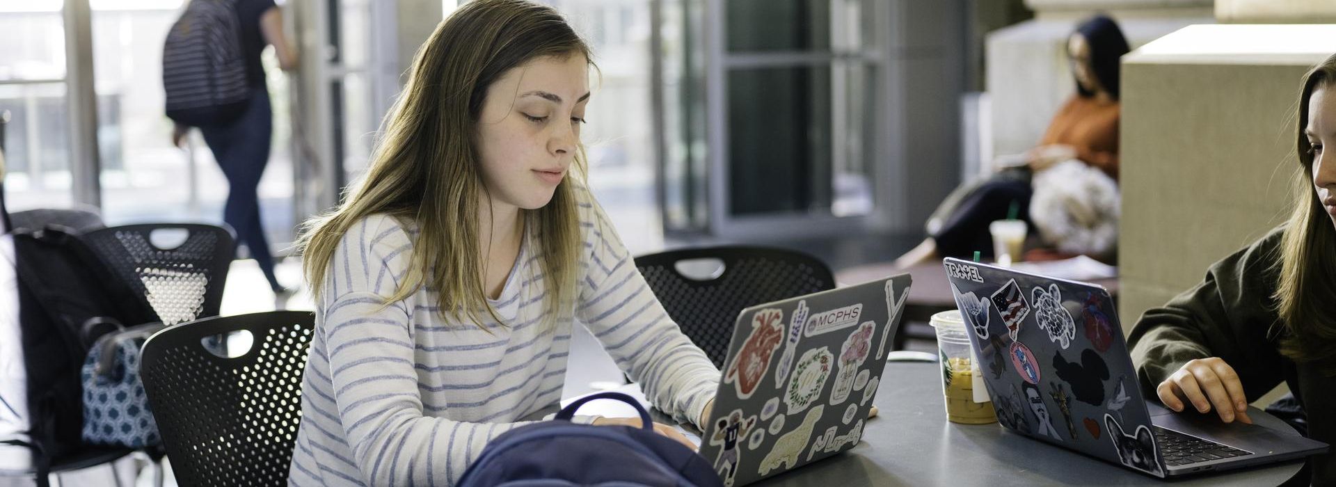  Female student sitting a table with laptop. 