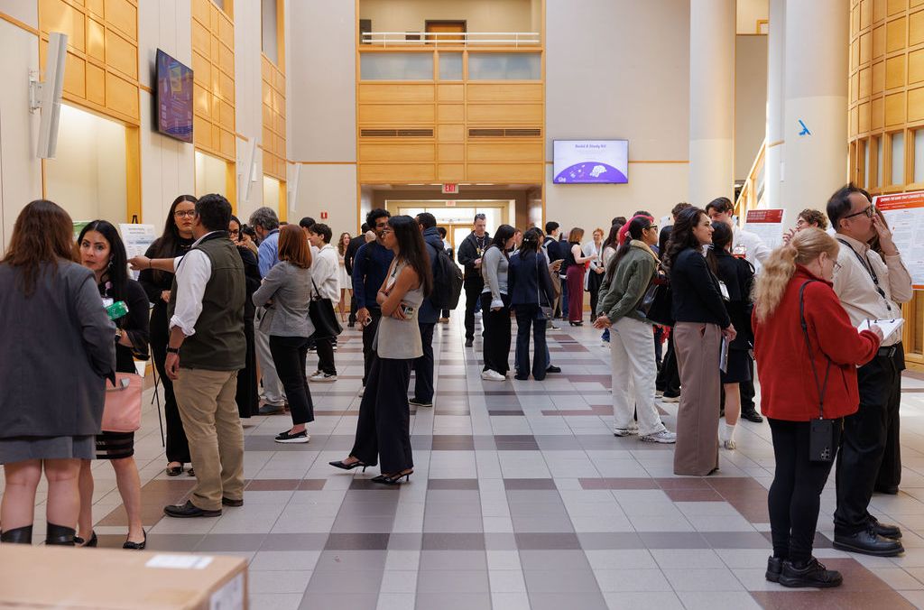 Students reviewing research posters at the MCPHS Student Research Conference.