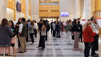 Students reviewing research posters at the MCPHS Student Research Conference.