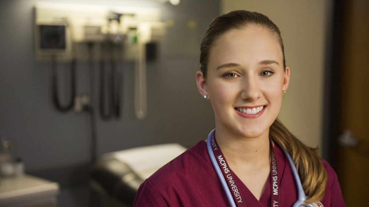 Smiling female student in scrubs. 