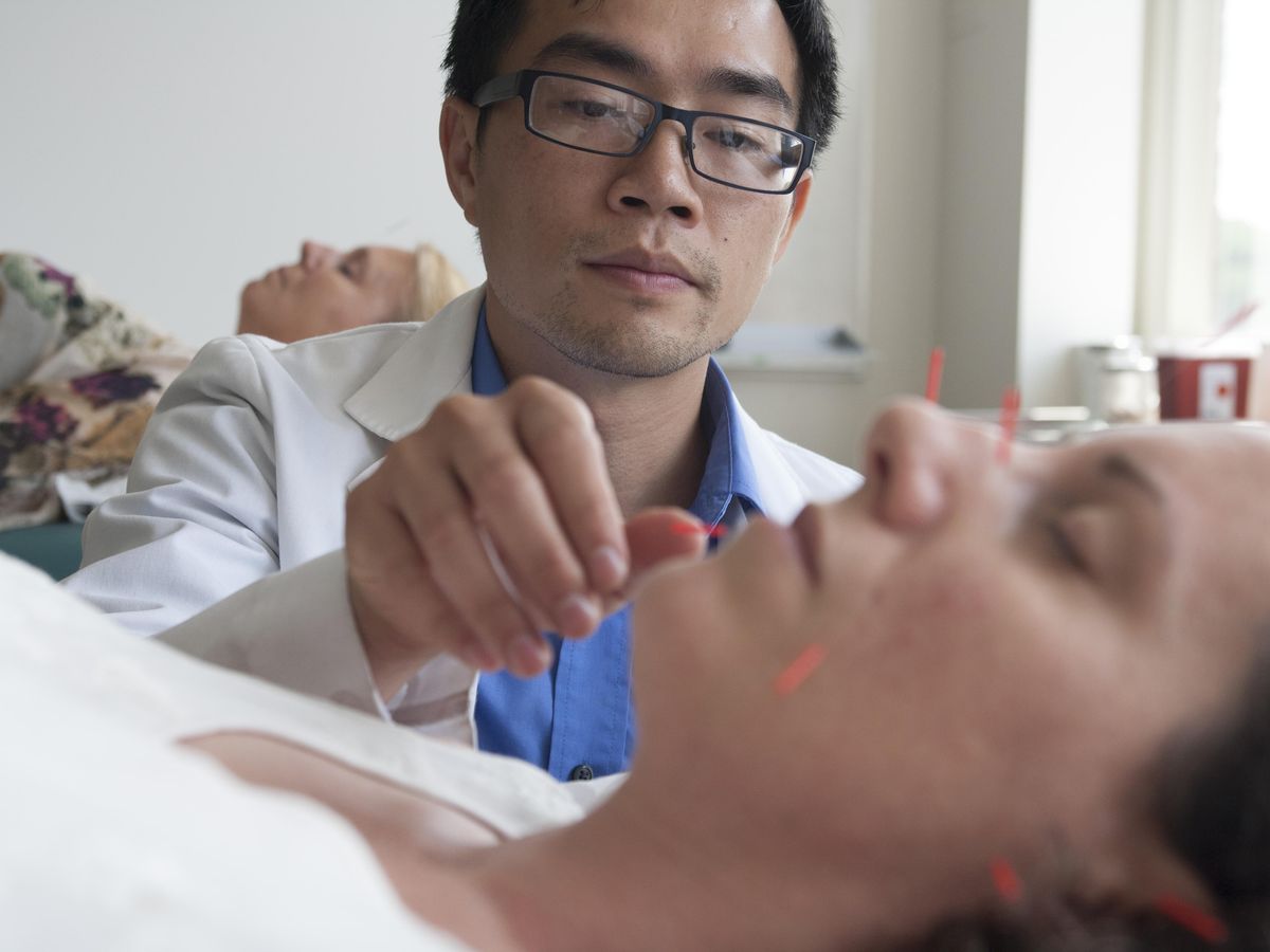 male acupuncture student removing needles from female patient