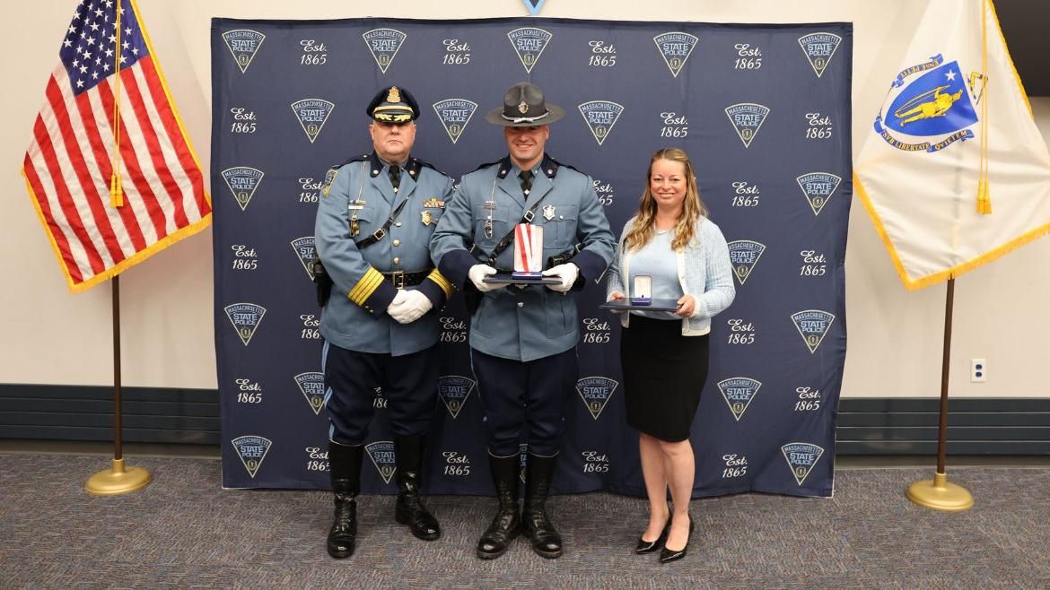 Laura Kelley and State Trooper Frederick J. Bohnenberger on stage holding the Lifesaving Awards.