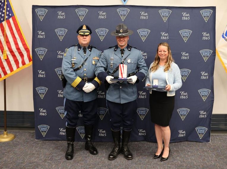 Laura Kelley and State Trooper Frederick J. Bohnenberger on stage holding the Lifesaving Awards.