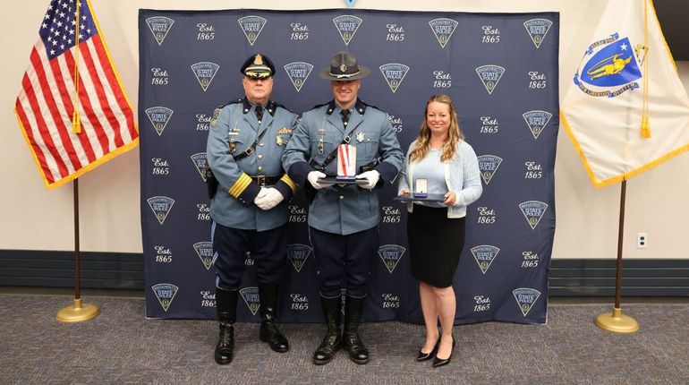 Laura Kelley and State Trooper Frederick J. Bohnenberger on stage holding the Lifesaving Awards.