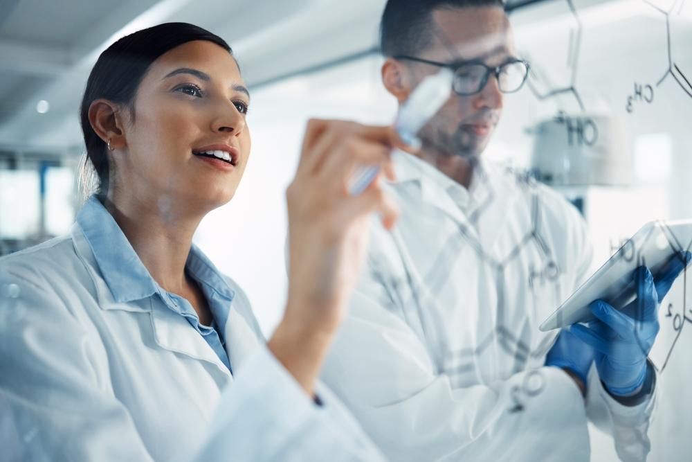 Female and male scientist in a lab setting. 