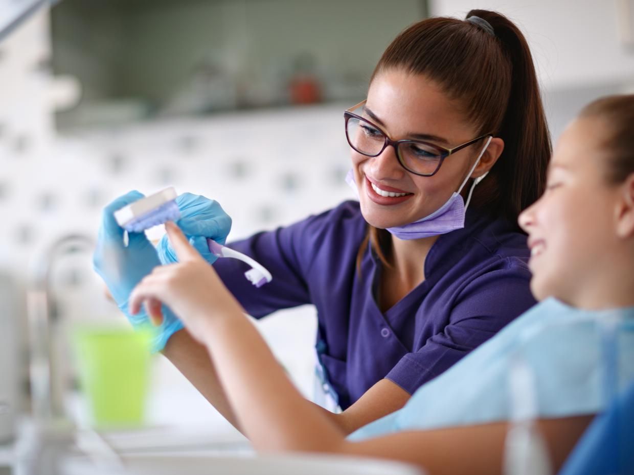 Dental Hygienist showing young patient mold of teeth. 