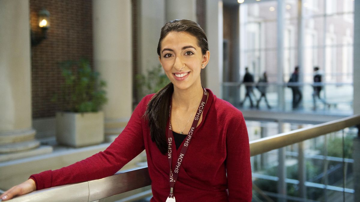 Smiling female student wearing a lanyard. 