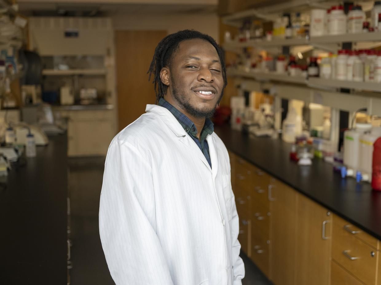 Smiling male student in a lab. 