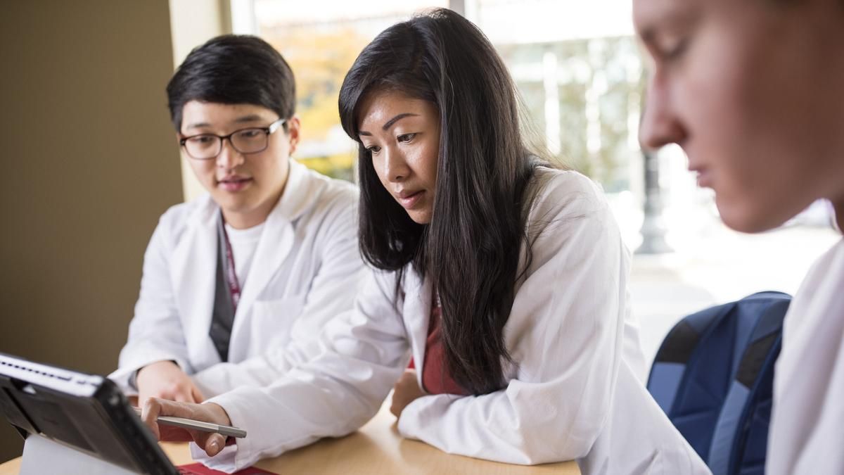 Students looking at a laptop. 