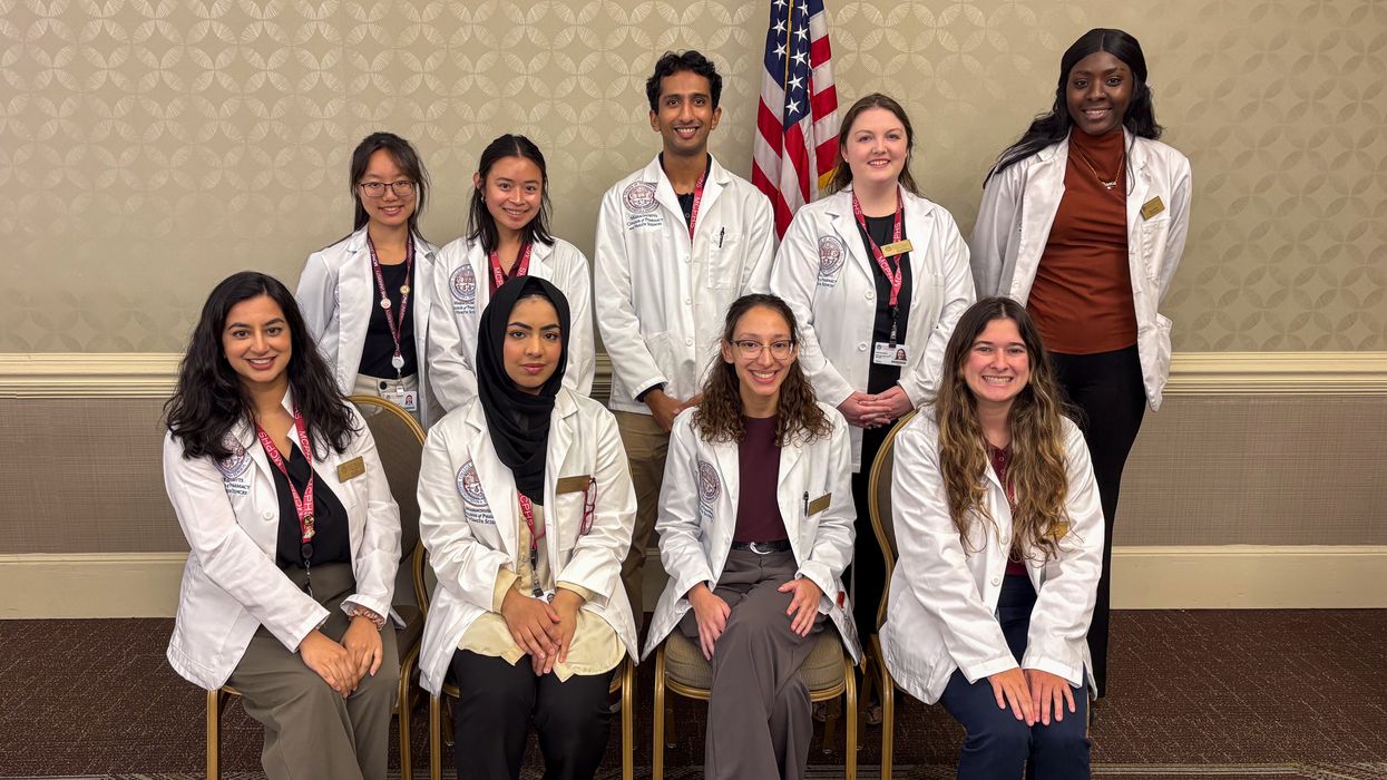 Nine students from Massachusetts College of Pharmacy and Health Sciences (MCPHS) smiling before a presentation on falls awareness.