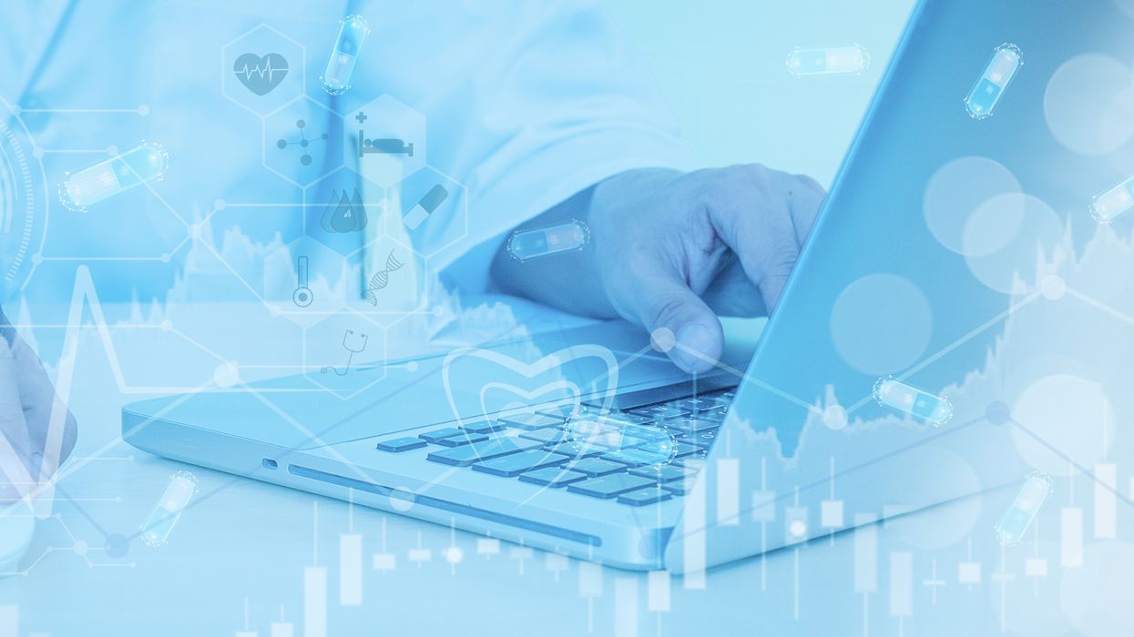 Close up of hand on laptop and medical icons. 