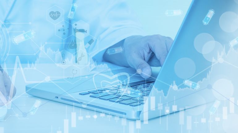 Close up of hand on laptop and medical icons. 