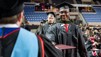 Students in cap and gowns at Commencement. 