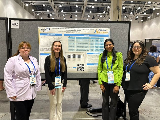 Students at Aspiring Academics program stand in front of poster.