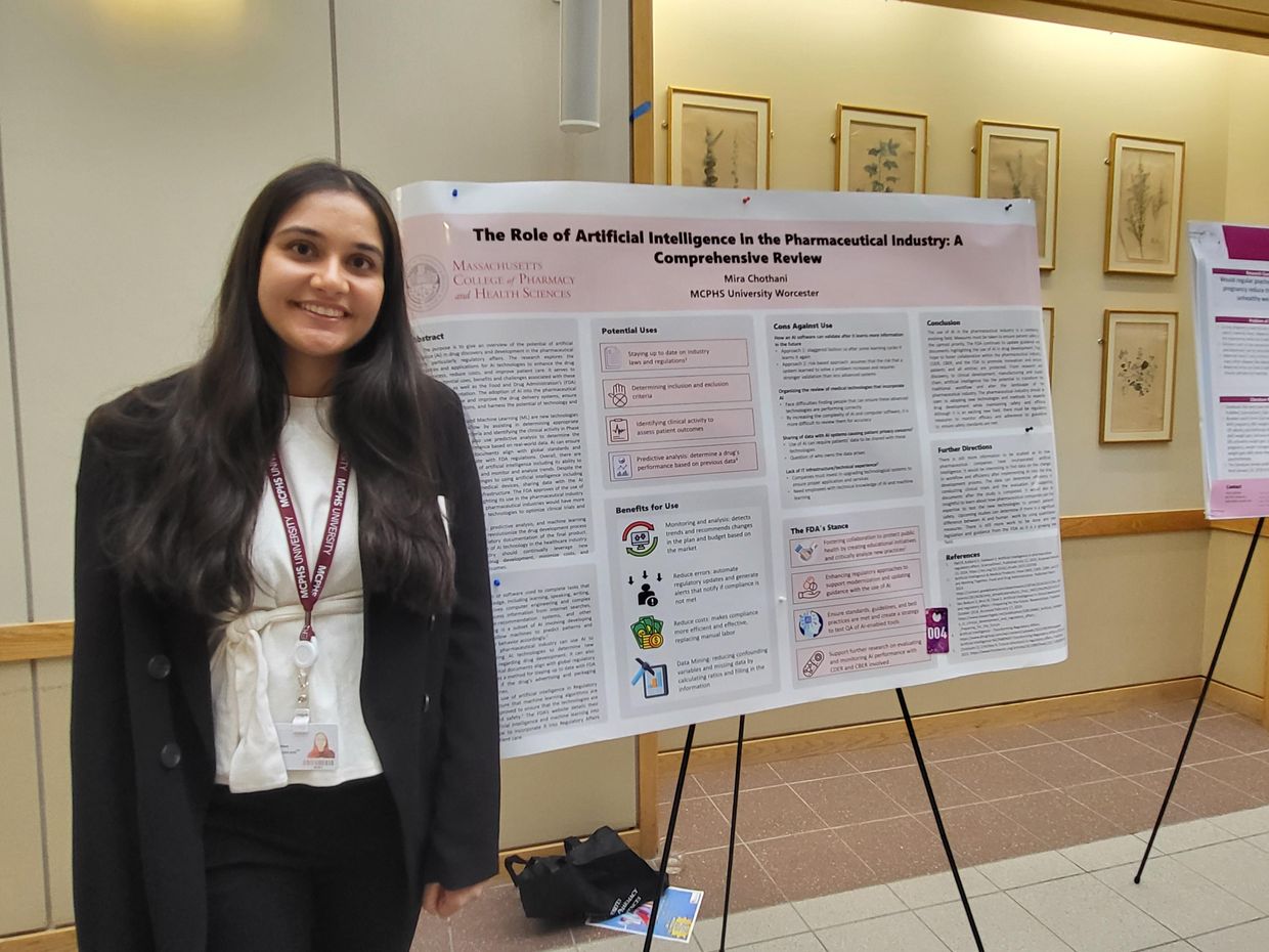 Student standing in front of research poster.