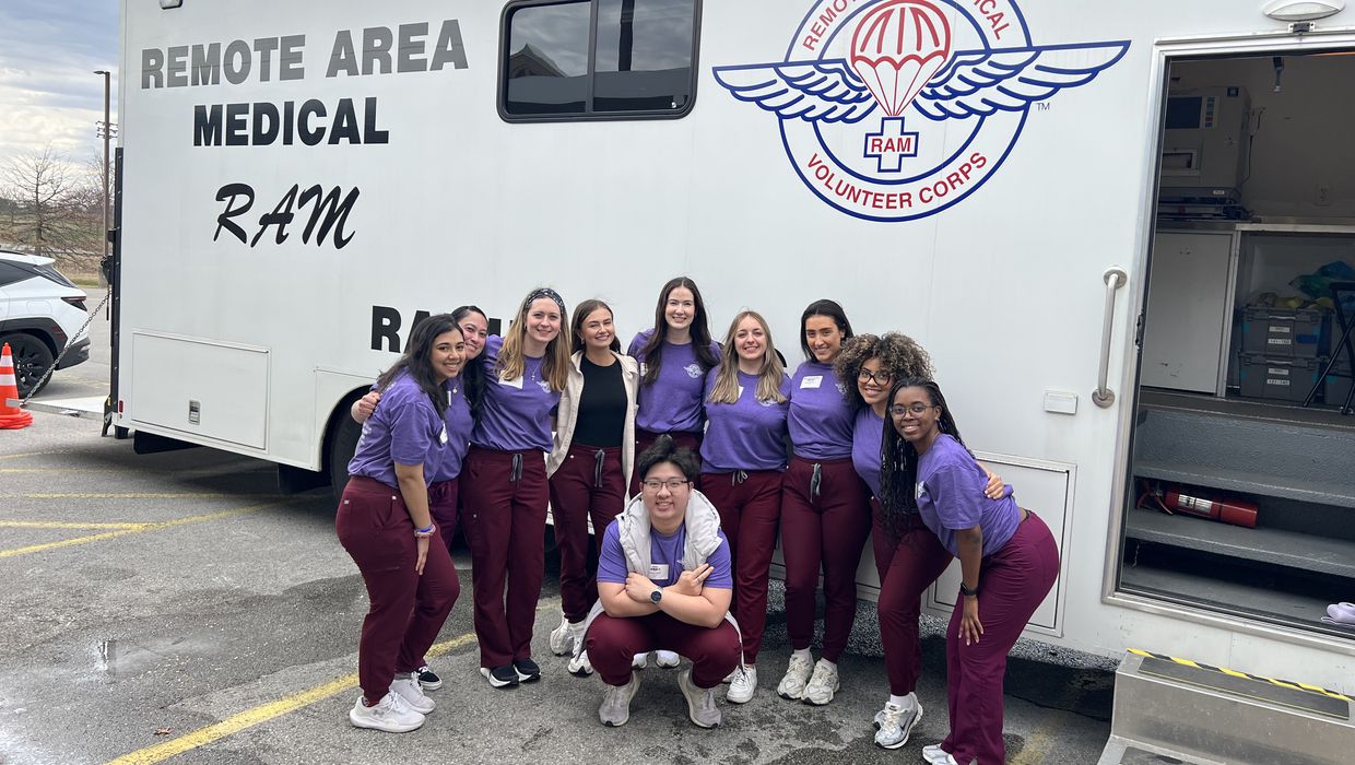MCPHS Optometry Students standing in front of a van