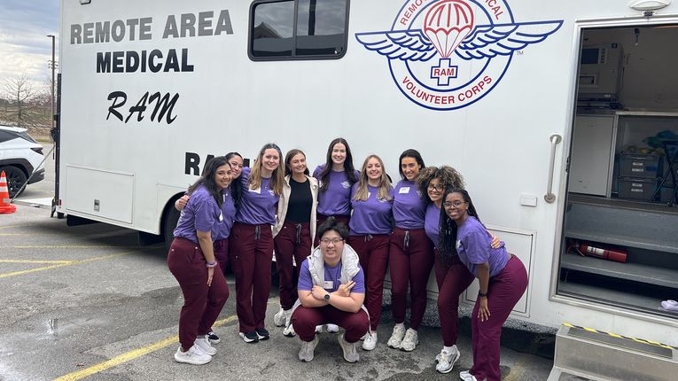 MCPHS Optometry Students standing in front of a van