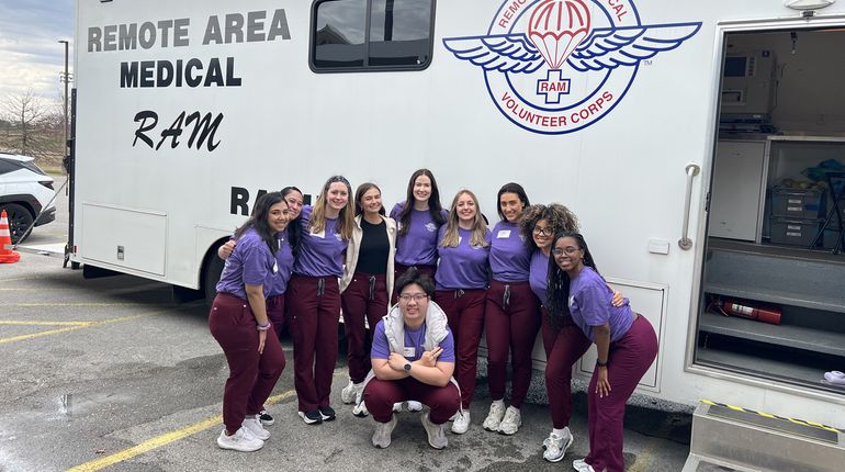 MCPHS Optometry Students standing in front of a van