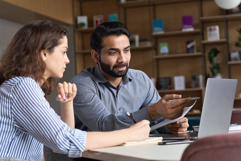 Woman and man in front of a laptop in a discussion. 