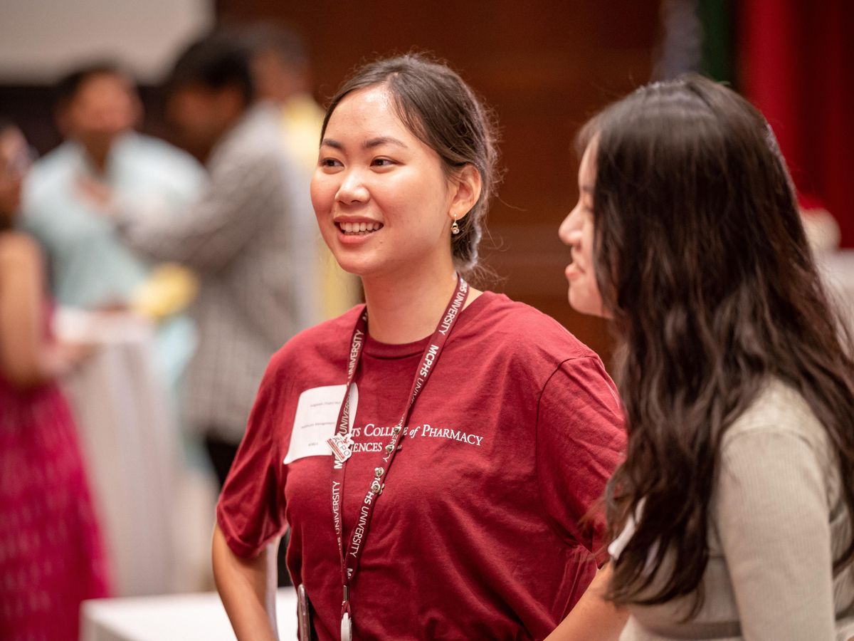 Smiling female student wearing an MCPHS Lanyard.