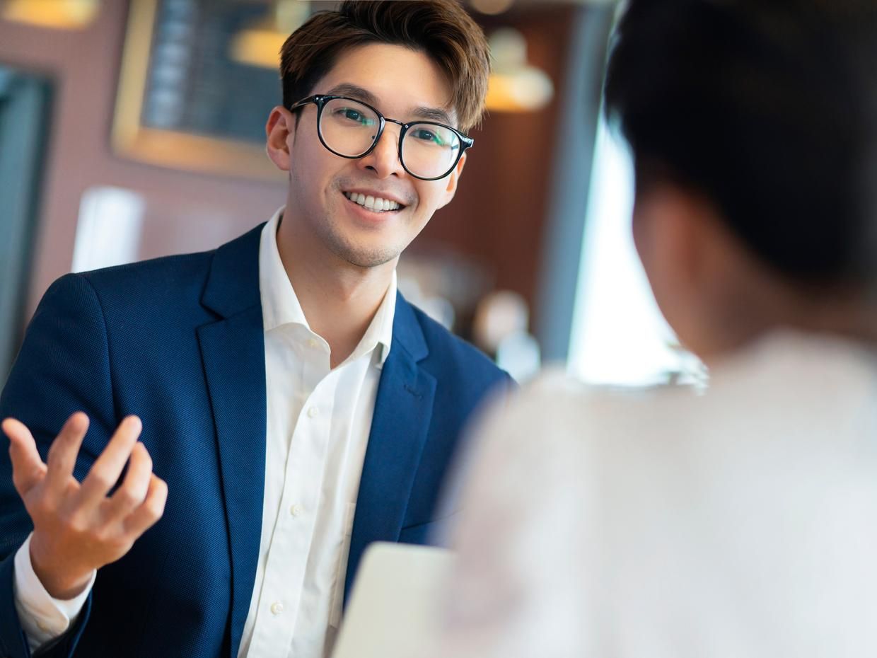 Man in business attire talking to woman. 