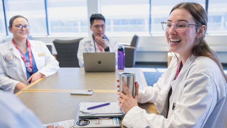 Physicians Assistant students hanging out in the library area on the Manchester campus and working in the PA lab.