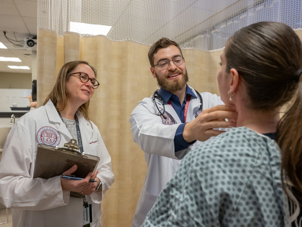 Physicians Assistant students hanging out in the library area on the Manchester campus and working in the PA lab.