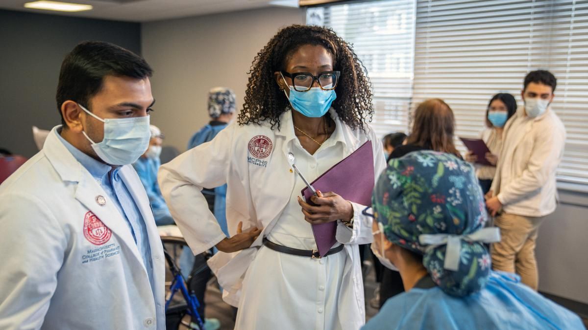 MCPHS students from the pharmacy and dental programs collaborate during an interprofessional education initiative, offering comprehensive exams to older adults in underserved communities. (Ian MacLellan photo)