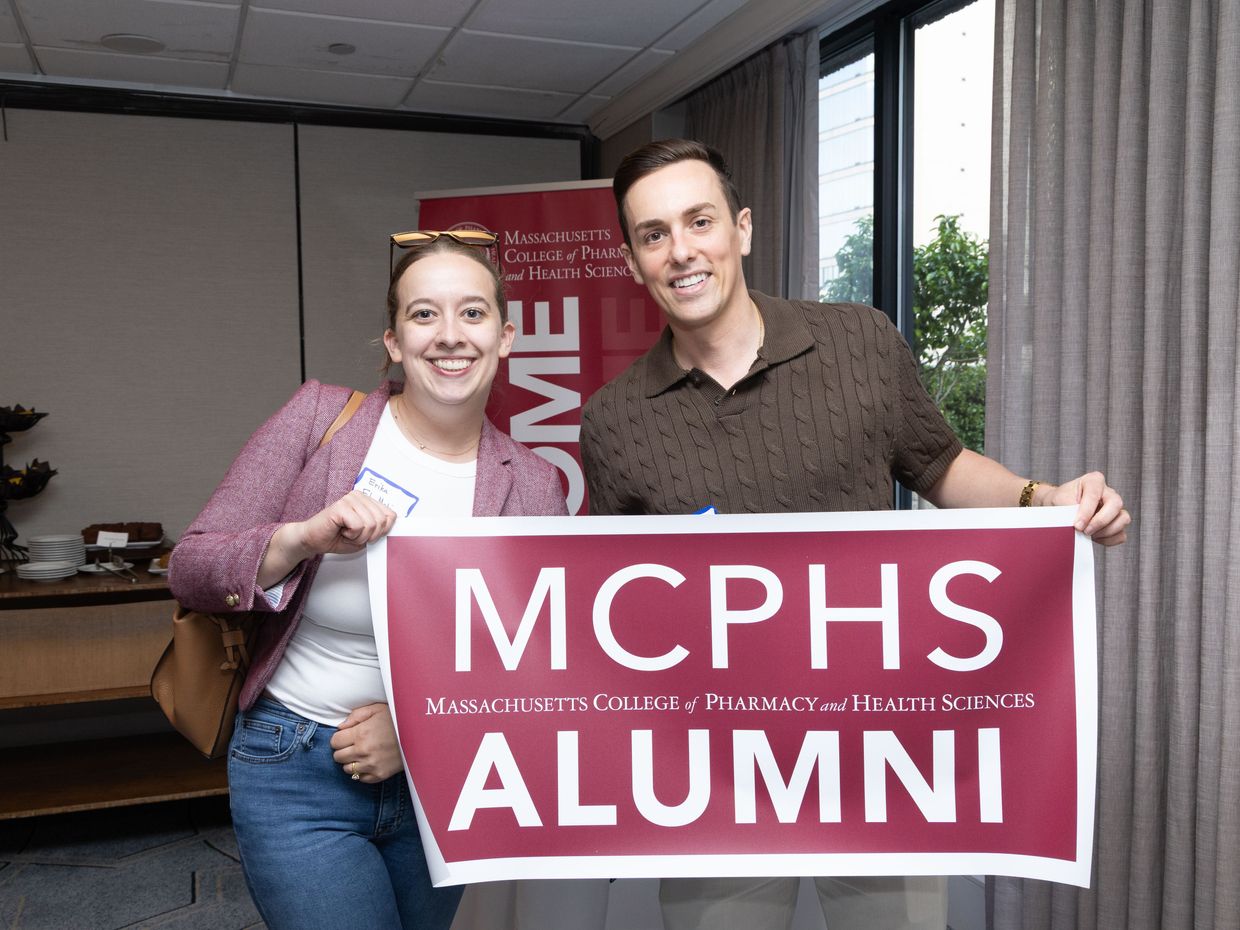 woman and man holding mcphs alumni sign