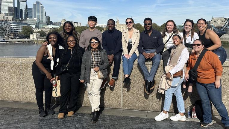 A group of students from the School of Healthcare Business and Technology pose for a photo near the Tower Bridge in London.