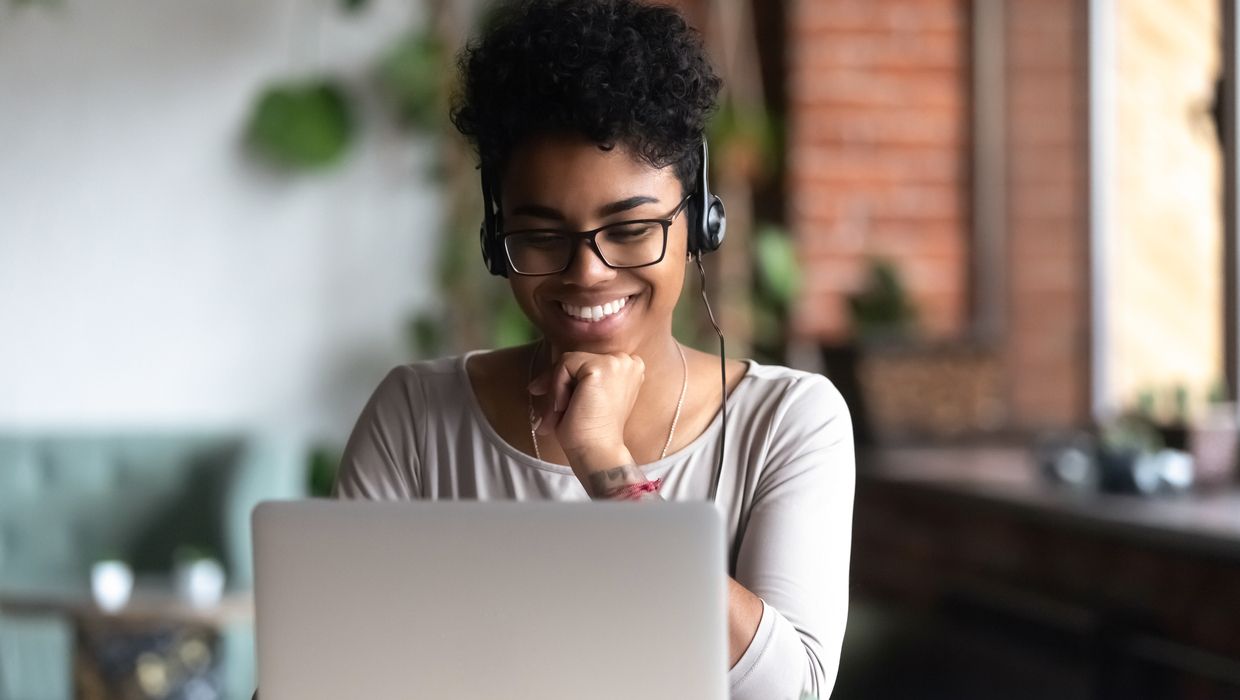 Woman in front of laptop with headphones. 