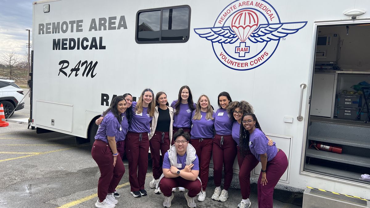 MCPHS Optometry Students standing in front of a van