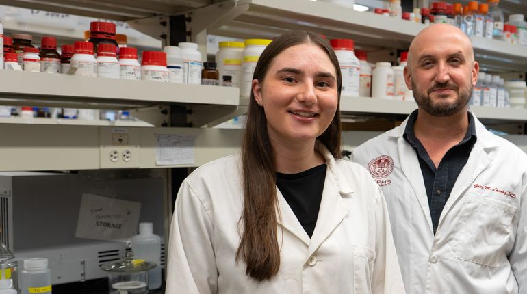 Penelope Pando and Greg Landry stand in a lab.