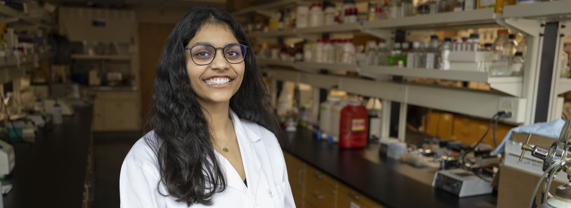 Smiling pharmacy student in a lab setting.