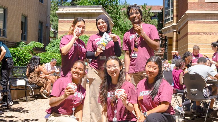 MCPHS students smiling and holding snacks.