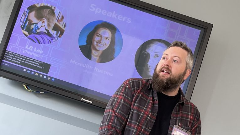 Michael Anthony stands in front of a screen.