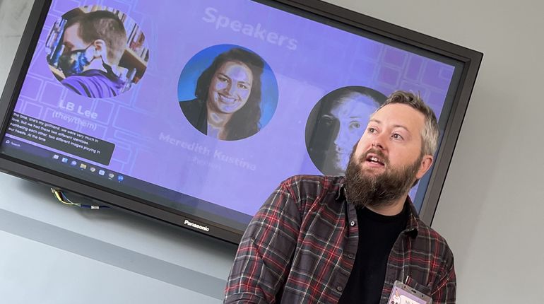 Michael Anthony stands in front of a screen.