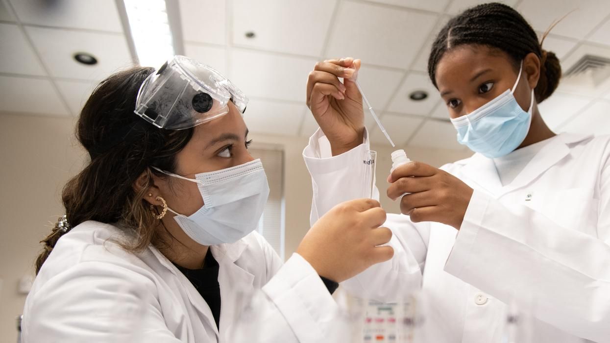 MCPHS students in the chemistry lab inserting fluid into a tube. 