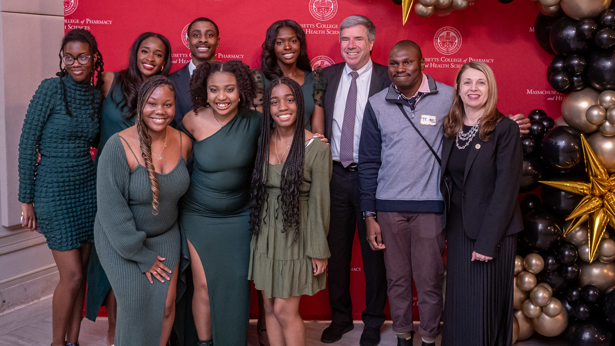 Students stand with President Richard Lessard and Provost Caroline Zeind at the MCPHS Black Excellence Dinner. 