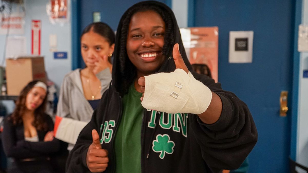 A student with hand bandaged with thumb up.