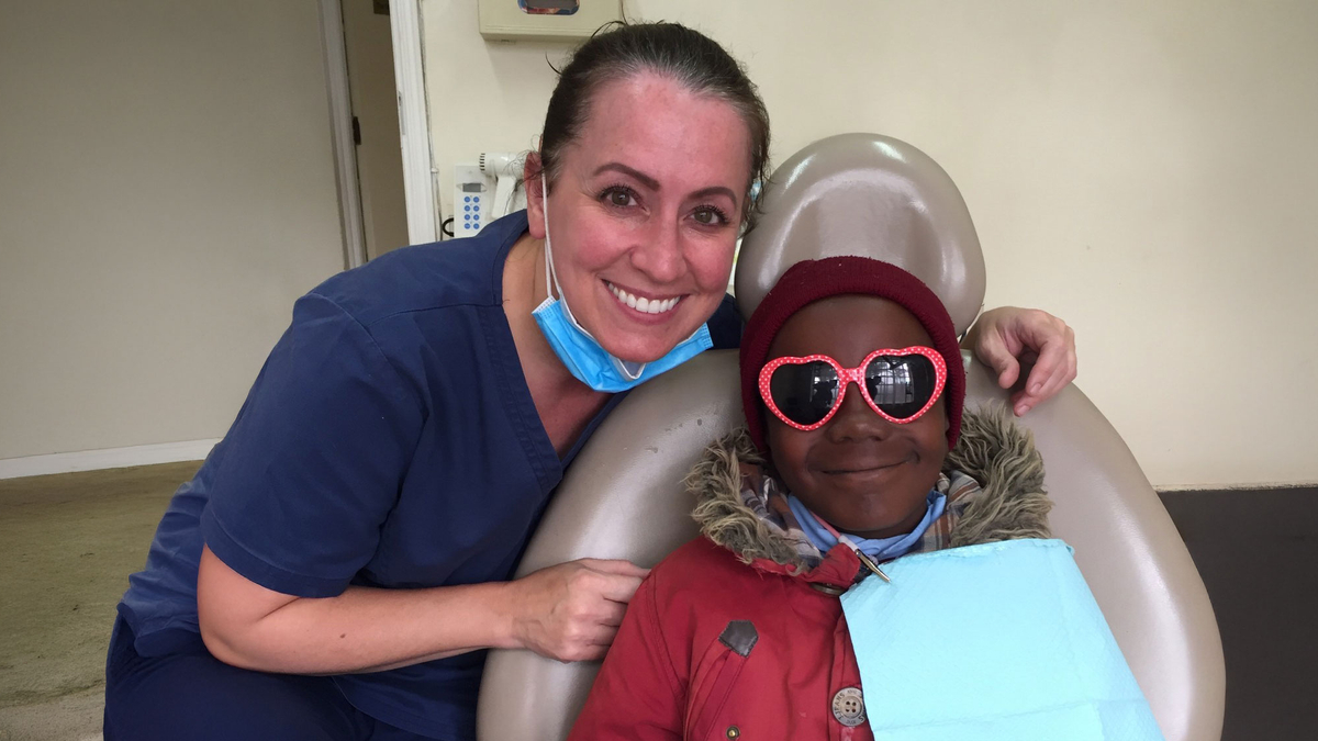 Associate Professor Jaymi-Lyn Adams stands next to a patient in Kenya.